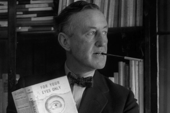 English author Ian Fleming (1908-1964) in his study with one of the series of James Bond novels that he wrote.