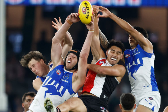 Tristan Xerri of the Kangaroos and Mitch Owens of the Saints compete for the ball.