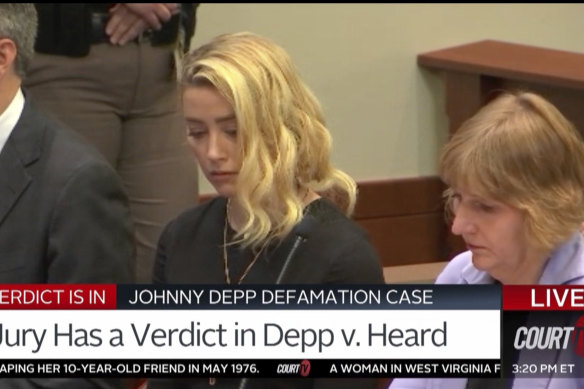 Amber Heard reacts, with her lawyer Elaine Bredehoft at right, as the verdict is read in the courtroom.