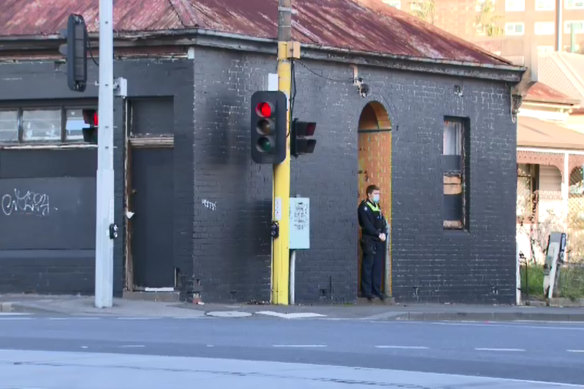 Police officer outside North Melbourne property where the alleged attack occurred. 