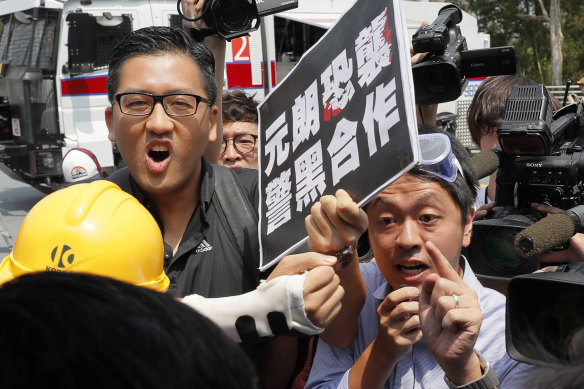 Pro-democracy lawmakers Lam Cheuk-ting, left, and Ted Hui, right, argue with pro-Beijing lawmaker Junius Ho during a demonstration of an anti-riot vehicle equipped in Hong Kong last year.