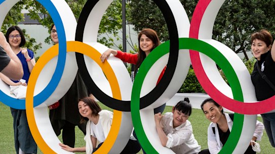 People have their photographs taken next to the Olympic Rings on June 03, 2021 in Tokyo, Japan.