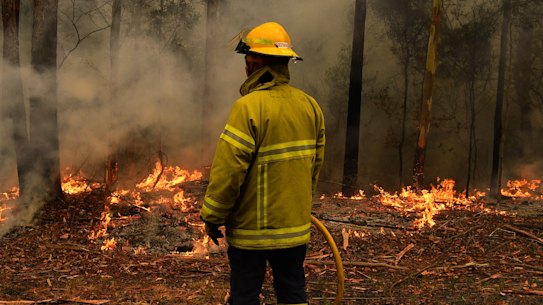 Firefighters contain a blaze on Sunday beside the Princes Highway between Nowra and Batemans Bay on NSW's South Coast.
