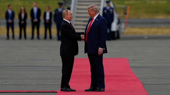 Donald Trump greets Vladimir Putin after the Russian leader lands in Alaska.