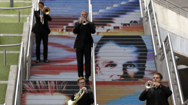 Musicians with the Royal Philharmonic Orchestra play on the Spanish Steps at Wembley Park in London on Saturday.