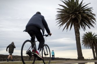 Mind the puddle: people out along Beach Road in Albert Park enjoy the last day of winter.