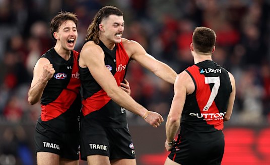 Essendon players celebrate their come-from-behind win over Fremantle.
