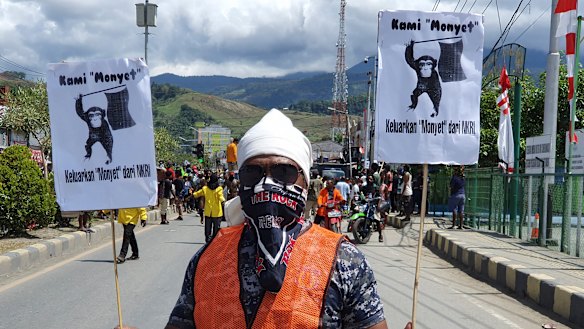 A protester holds posters that read "We are monkeys, monkeys want to be separated from Indonesia", during a rally in Abepura, Papua province, Indonesia. 