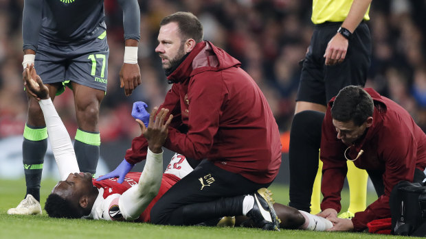 Arsenal's Danny Welbeck receives medical treatment.