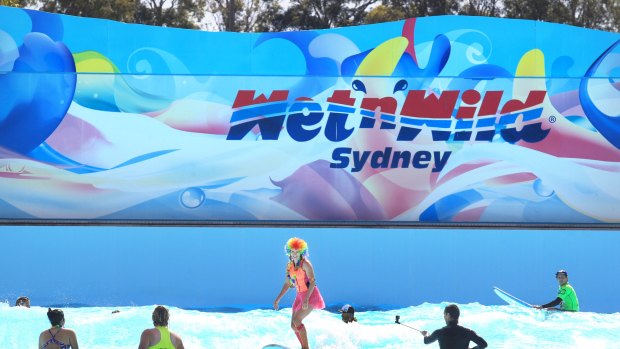 Patrons surf in the wave pool under the old Wet 'n' Wild banner at an event in the Western Sydney water park.