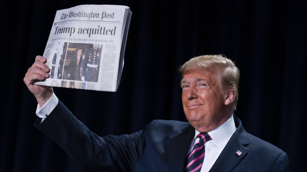 US President Donald Trump shows off the headline of his acquittal. 