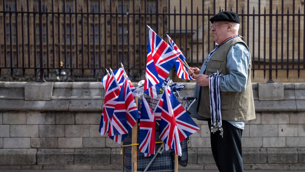 A vendor holds Union flags and whistles for sale near the Houses of Parliament