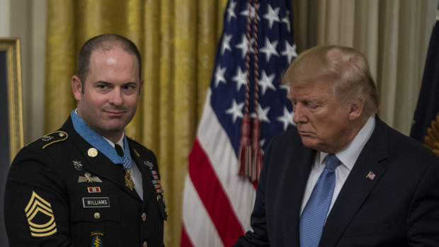 US President Donald Trump shakes hands with Army Master Sergeant Matthew Williams. 