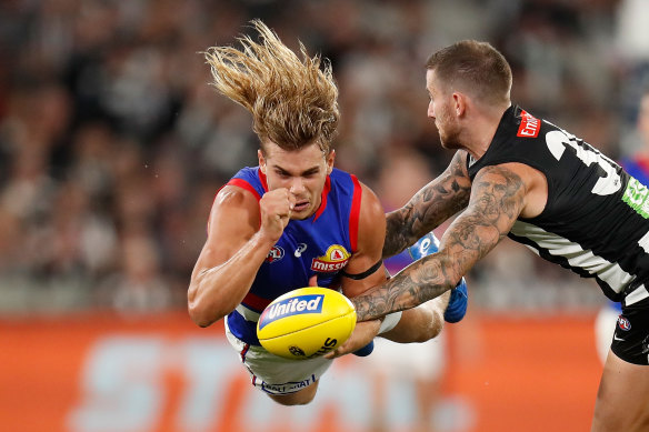 Bailey Smith leaps into a handball as Jeremy Howe tackles.