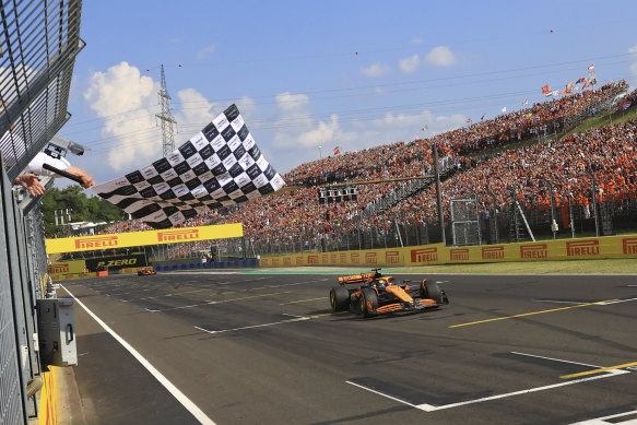 McLaren driver Oscar Piastri takes the chequered flag to win the Hungarian Formula 1 Grand Prix on Monday morning (AEST).