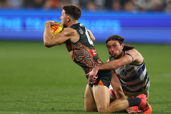 Toby Greene of the Giants is tackled by Jack Henry of the Cats.
