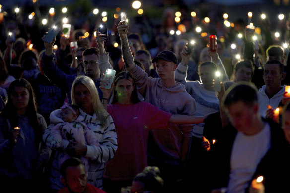 People attend a vigil for the victims of the mass shooting in Plymouth, England on Friday.