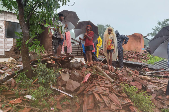 People watch rescue efforts after a landslide in Taliye village, in the western Indian state of Maharashtra, Friday, July 23, 2021. 