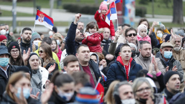 People wave Serbian national flags as they take part in a rally in front of Serbia’s National Assembly over the cancellation of Djokovic’s visa. 