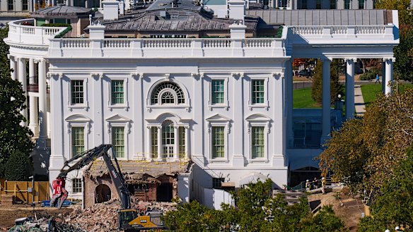Construction workers watch as work continues on a largely demolished part of the East Wing of the White House.
