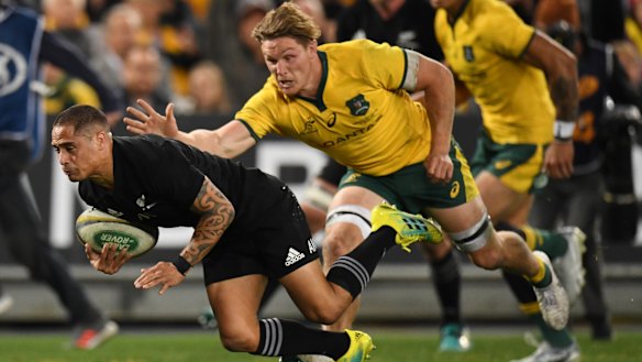 Tide turns: Aaron Smith scores a try despite the efforts of Michael Hooper.