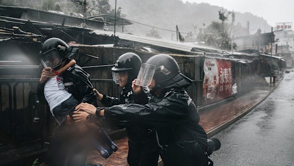 A police officer carries a girl in rain during a No 10 Hurricane Signal raised for Typhoon Mangkhut in Hong Kong on Sunday.