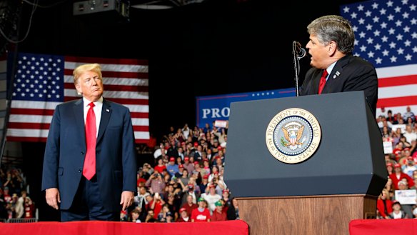 President Donald Trump listens as Fox News' Sean Hannity called the media 'fake news' and said the President kept his promises.
