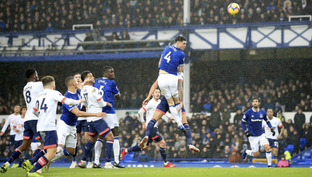 Michael Keane flies high for Everton.