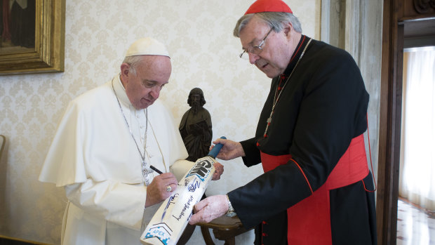 Pope Francis signs a cricket bat he received from Cardinal George Pell in 2015.