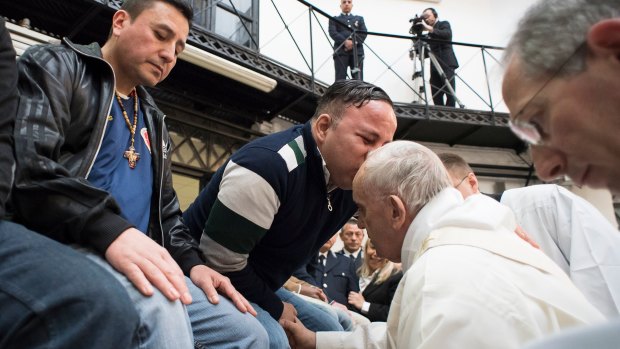 Pope Francis washes the feet of inmates during his visit to the Regina Coeli detention centre in Rome.