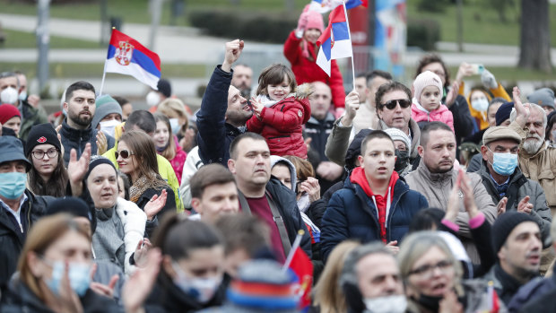 People wave Serbian national flags as they take part in a rally in front of Serbia’s National Assembly over the cancellation of Djokovic’s visa. 