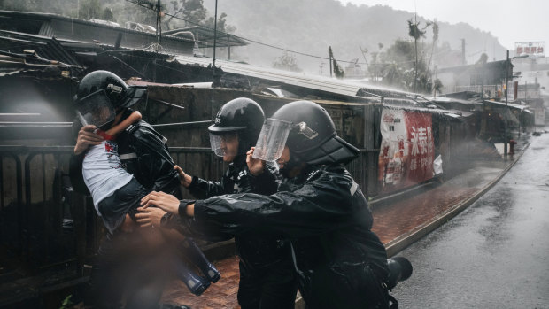 A police officer carries a girl in rain during a No 10 Hurricane Signal raised for Typhoon Mangkhut in Hong Kong on Sunday.