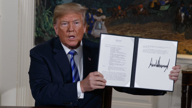 US President Donald Trump shows a signed memorandum to pull out of the Iran nuclear deal.