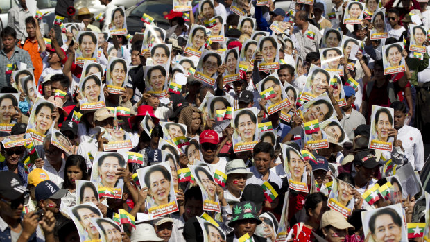 Supporters hold portraits of Myanmar leader Aung San Suu Kyi during a march in Yangoon, Myanmar, on Tuesday.