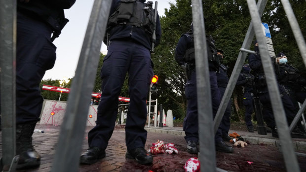 Polish police stand guard after activists threw paint symbolising blood close to the parliament in Warsaw, Poland.