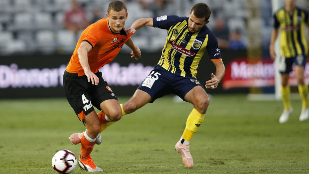 Jordan Murray of the Mariners (right) contests the ball with Daniel Bowles of the Roar during the Round 14 A-League match at Central Coast Stadium in Gosford on Sunday.