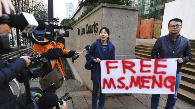 People hold a sign at a Vancouver, British Columbia courthouse prior to the bail hearing for Meng Wanzhou, Huawei's chief financial officer.