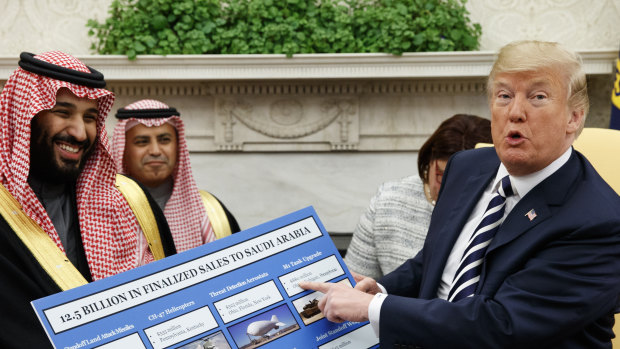 US President Donald Trump holds a chart highlighting arms sales to Saudi Arabia during a meeting with Saudi Crown Prince Mohammed bin Salman in the Oval Office in March.