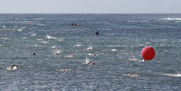 Swimmers head out around a buoy on a glistening morning at the Malabar Magic.