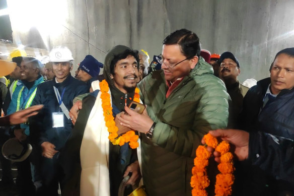 Singh Dhami, right, Chief Minister of the state of Uttarakhand, embraces a worker rescued from the site of an under-construction road tunnel that collapsed in Silkyara in the northern Indian state of Uttarakhand.