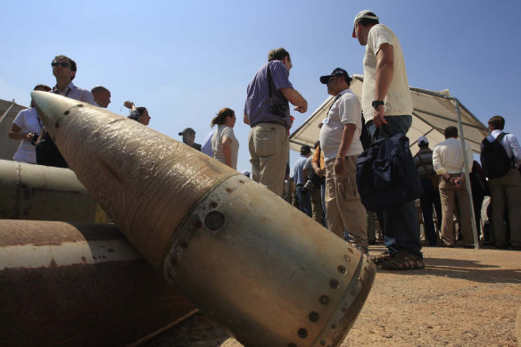 Activists and international delegations stand next to cluster bomb units, during a visit to a Lebanese military base.