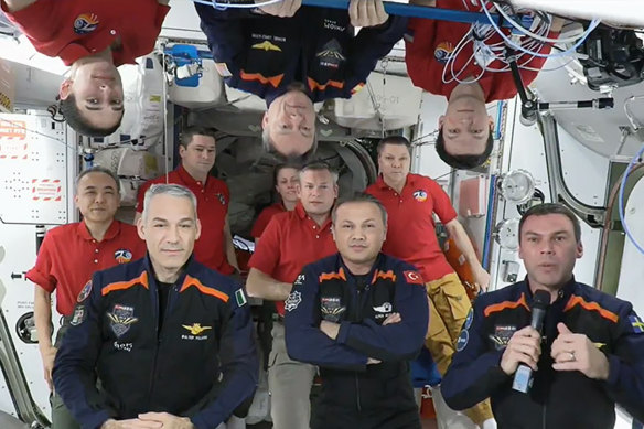 Four astronauts (in dark blue suits) on the International Space Station in February after travelling privately with Axiom Space.