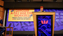 A screen descends behind One Nation Leader Senator Pauline Hanson at the National Press Club 