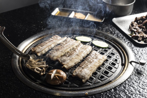 Cooking the pork belly on the grill.