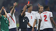 Referee Alireza Faghani shows a red card to Jarell Quansah.