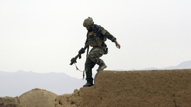 A US special operations forces soldier climbs down from a compound wall in Shewan, a former Taliban stronghold in Afghanistan's Farah province.