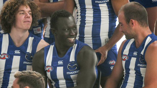 Happy homecoming: Majak Daw lines up for the team photo flanked by Ben Brown (left) and Ben Cunnington.