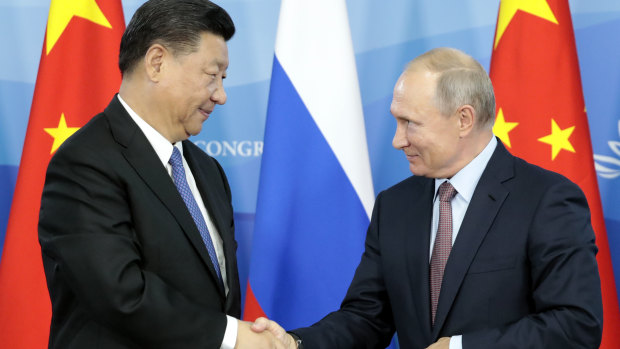 Russian President Vladimir Putin, right, shakes hands with Chinese President Xi Jinping after their news conference at the Eastern Economic Forum in Vladivostok, Russia, 
