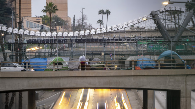 Tents sit on an overpass as traffic moves along US Highway 101 in Los Angeles, California.