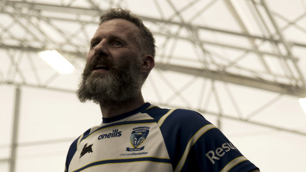Adam Hills wearing his Warrington Wolves jersey in the documentary Take His Legs.